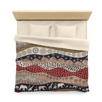 King duvet cover. Naive African elephants and giraffes artwork with primitive floral motifs in maroon, navy blue and earth tones.
