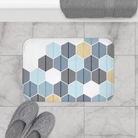 Abstract honeycomb-shaped trees design bath mat in navy blue, rackley blue, light blue and gold (not glittery) on a white background.