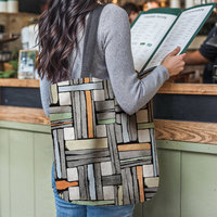 Mondrian Color Block Woven Tapestry Bag hanging on a woman's shoulder as she reads a menu at a restaurant counter.