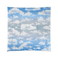 Queen comforter printed with fluffy white clouds on a blue and gray ombré sky background.