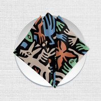 Napkins with Cute folk art of otherworldly dinosaurs, flora and fauna in brown, beige, green and blue on a black background.