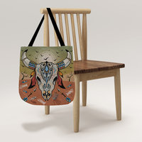 Cow Skull Tapestry Bag, Desert Sunset Colors Tote hanging from a chair.