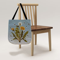 Dandelions and Bees Woven Tapestry Bag hanging on a chair.