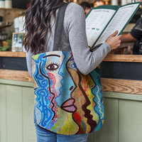 Abstract Faces Woven Tote, hanging on the shoulder of a young woman who is standing at a restaurant counter reading a menu.