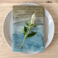 folded sandy beach design napkin on a white plate