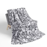 White hand-drawn folk art animals and plants printed on a lightweight, soft and plush two-sided velveteen throw blanket.