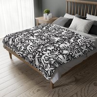 White hand-drawn folk art animals and plants printed on a lightweight, soft and plush two-sided velveteen throw blanket.