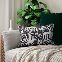 Lumbar pillow, Primitive white hand-drawn animals and plant life. One side is printed on a black background.