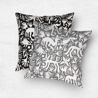 Primitive white hand-drawn animals and plant life. One side is printed on a black background and the other side is printed on a gray background.