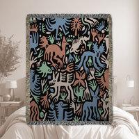 woven blanket with Modern folk art of otherworldly dinosaurs, flora and fauna in brown, beige, green and blue on a black background. 