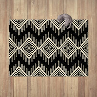 An Aztec or ethnic pattern geometrical design in black and beige for a neutral modern home laying on a wood floor