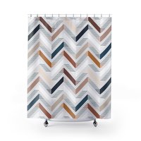 Shower curtain with an unusual abstract geometric zig-zag pattern in browns, blues, gray and white on an off-white textured background.