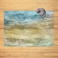 Abstract watercolor rug in teal, sand, and olive tones, displayed in a cozy living room with wood floors and a cat resting on the corner.