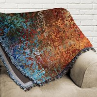 Abstract Ombré Woven Blanket in Southwestern Colors folded on a couch.