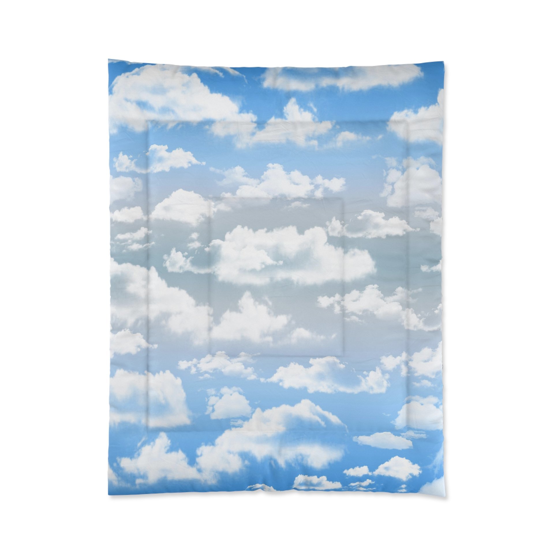 Twin comforter printed with fluffy white clouds on a blue and gray ombré sky background.