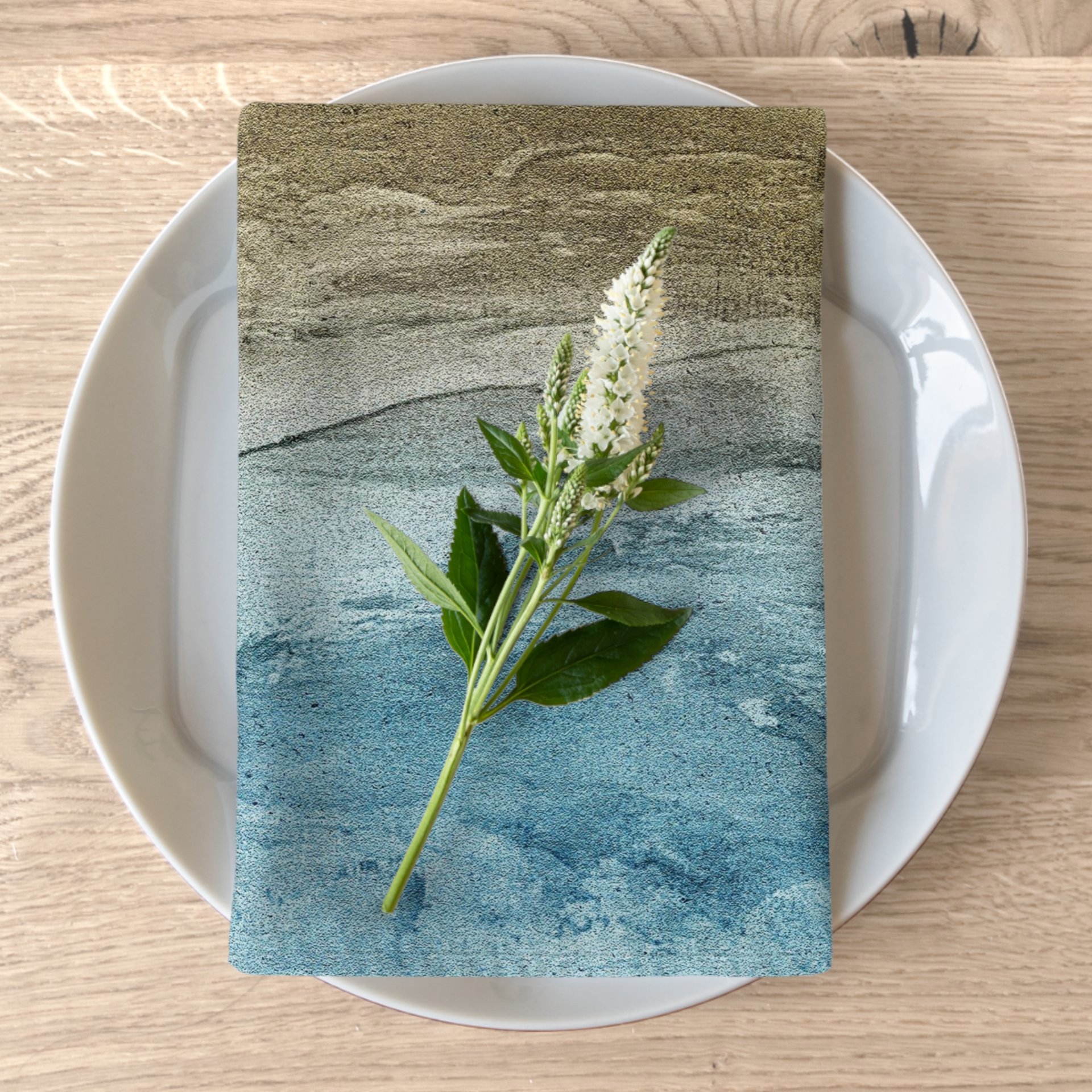 folded sandy beach design napkin on a white plate
