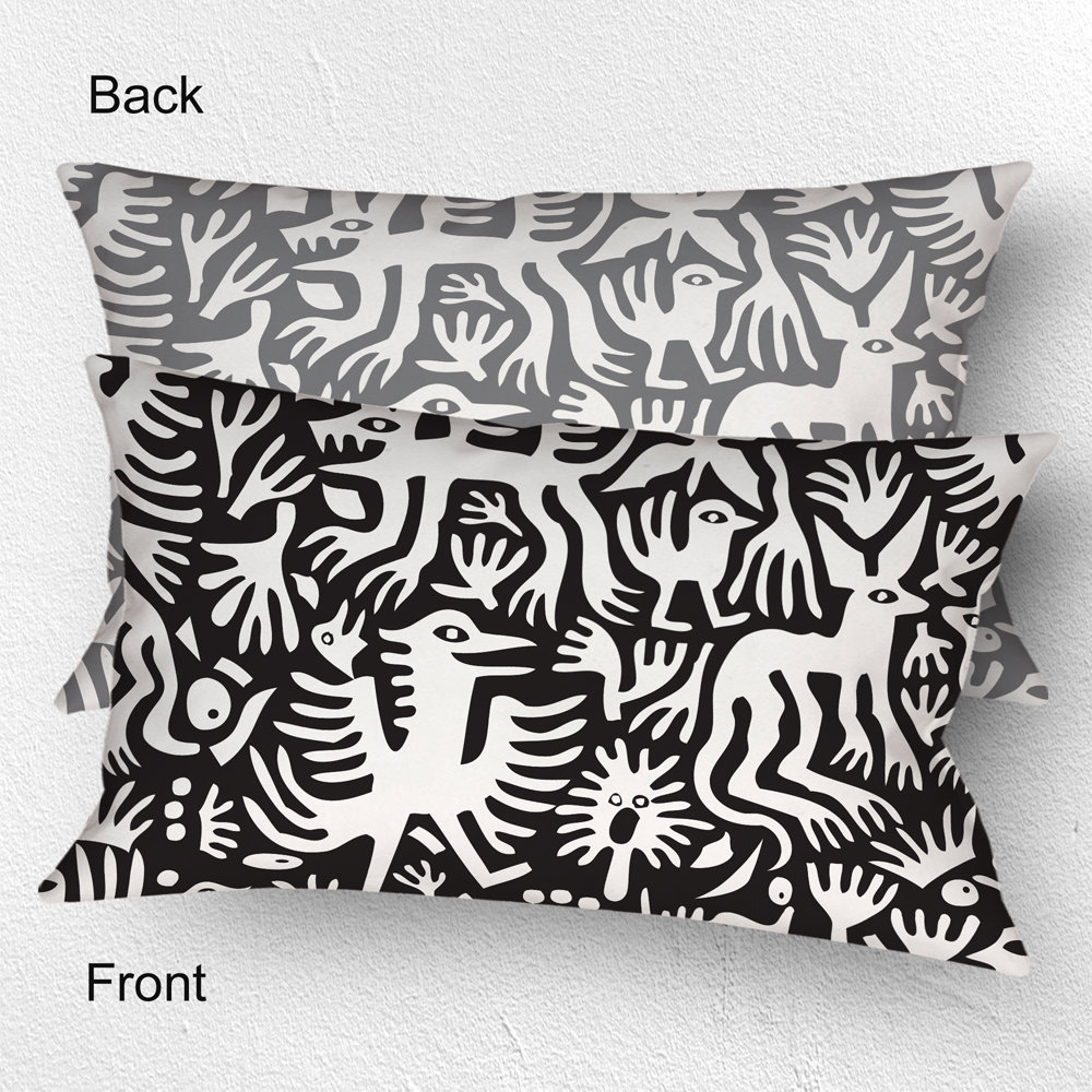Lumbar pillow, Primitive white hand-drawn animals and plant life. One side is printed on a black background and the other side is printed on a gray background
