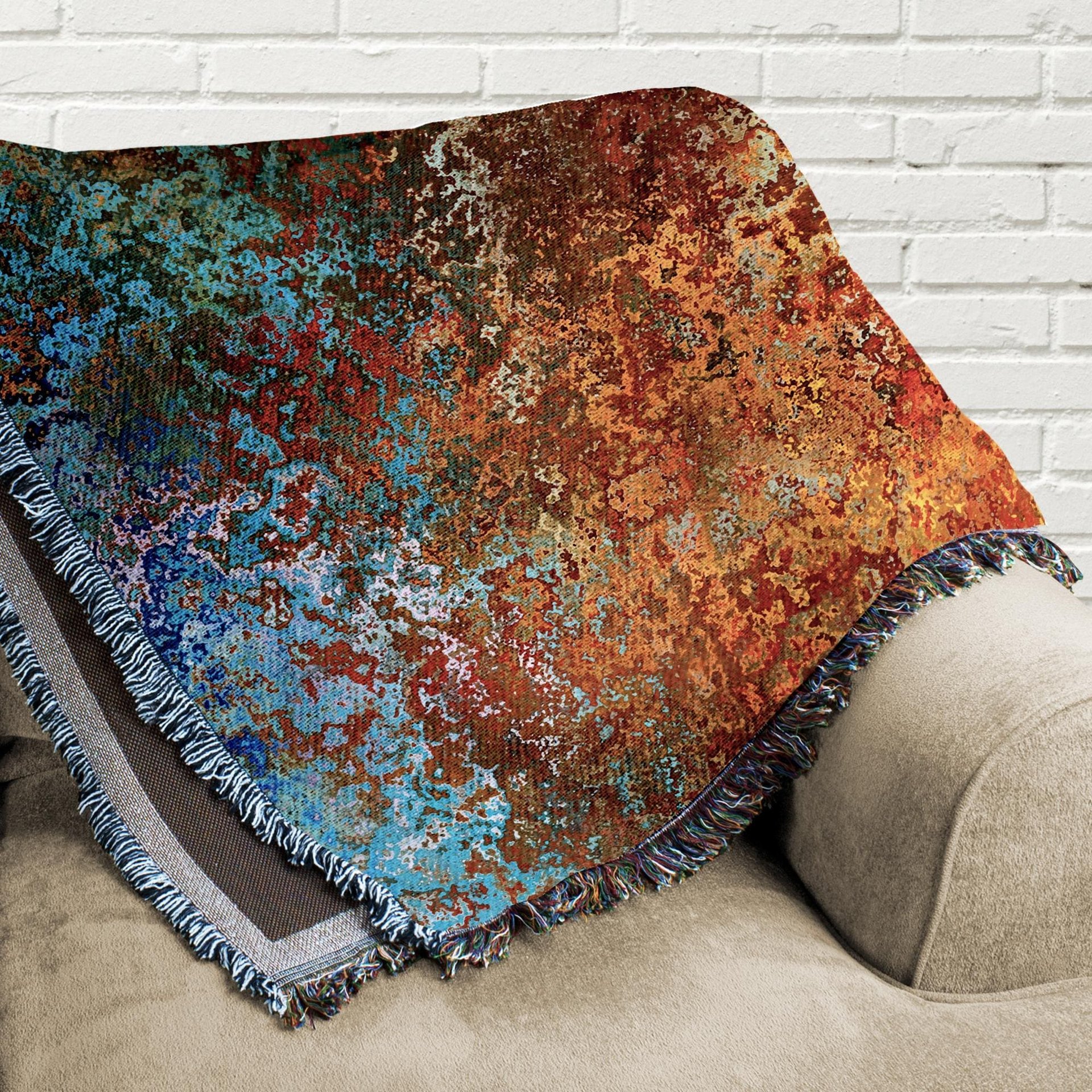 Abstract Ombré Woven Blanket in Southwestern Colors folded on a couch.