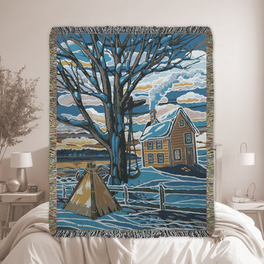 Woven blanket of a Canadian winter landscape scene with trees, a country home, and a tipi outside the fenced backyard in blues, grays and browns.